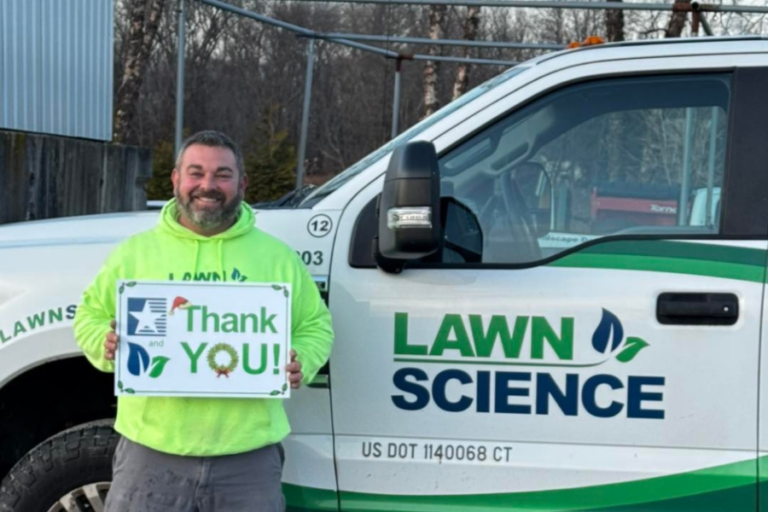 Lawn Science team member beside a company truck